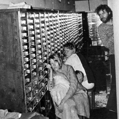 Clark Olofsson is looking onto something as two hostages are sitting next to him.